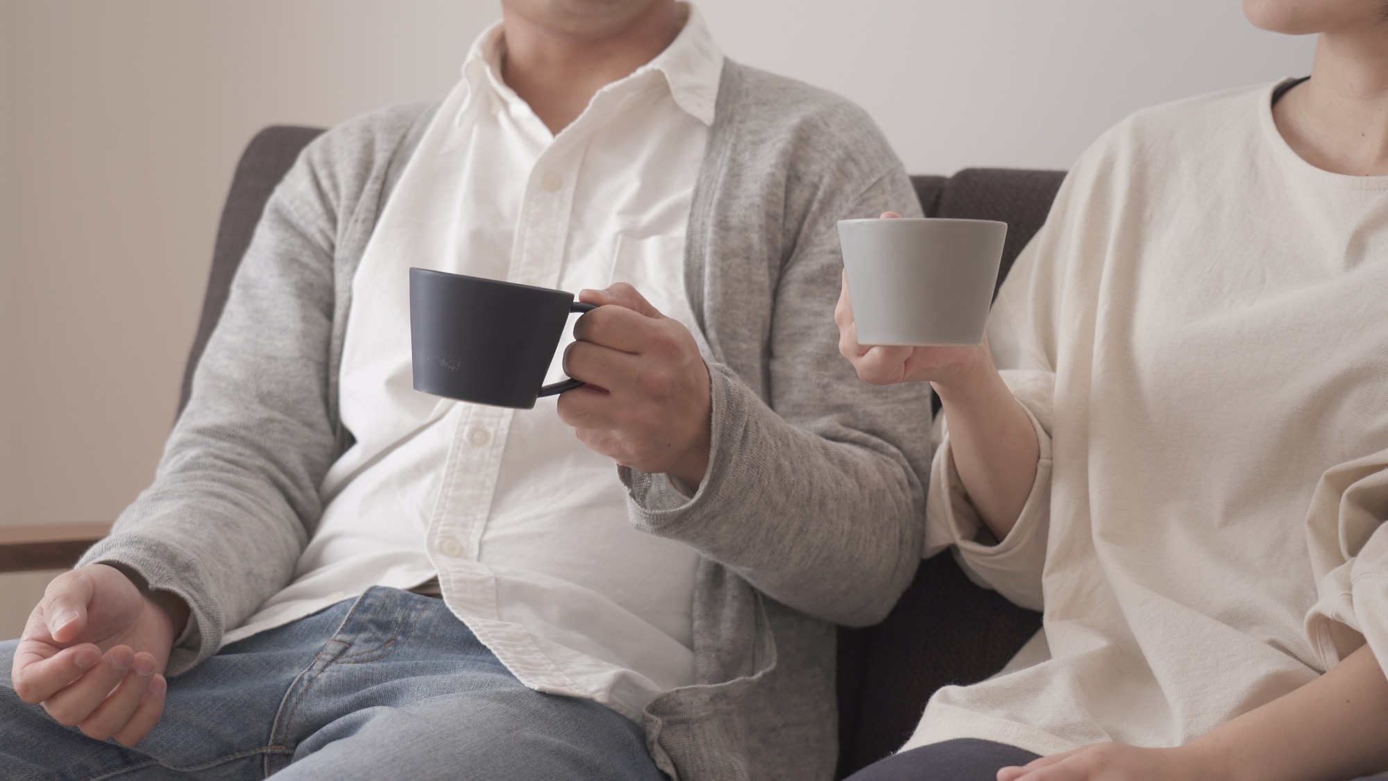 マグカップを持って座っている夫婦　カップル