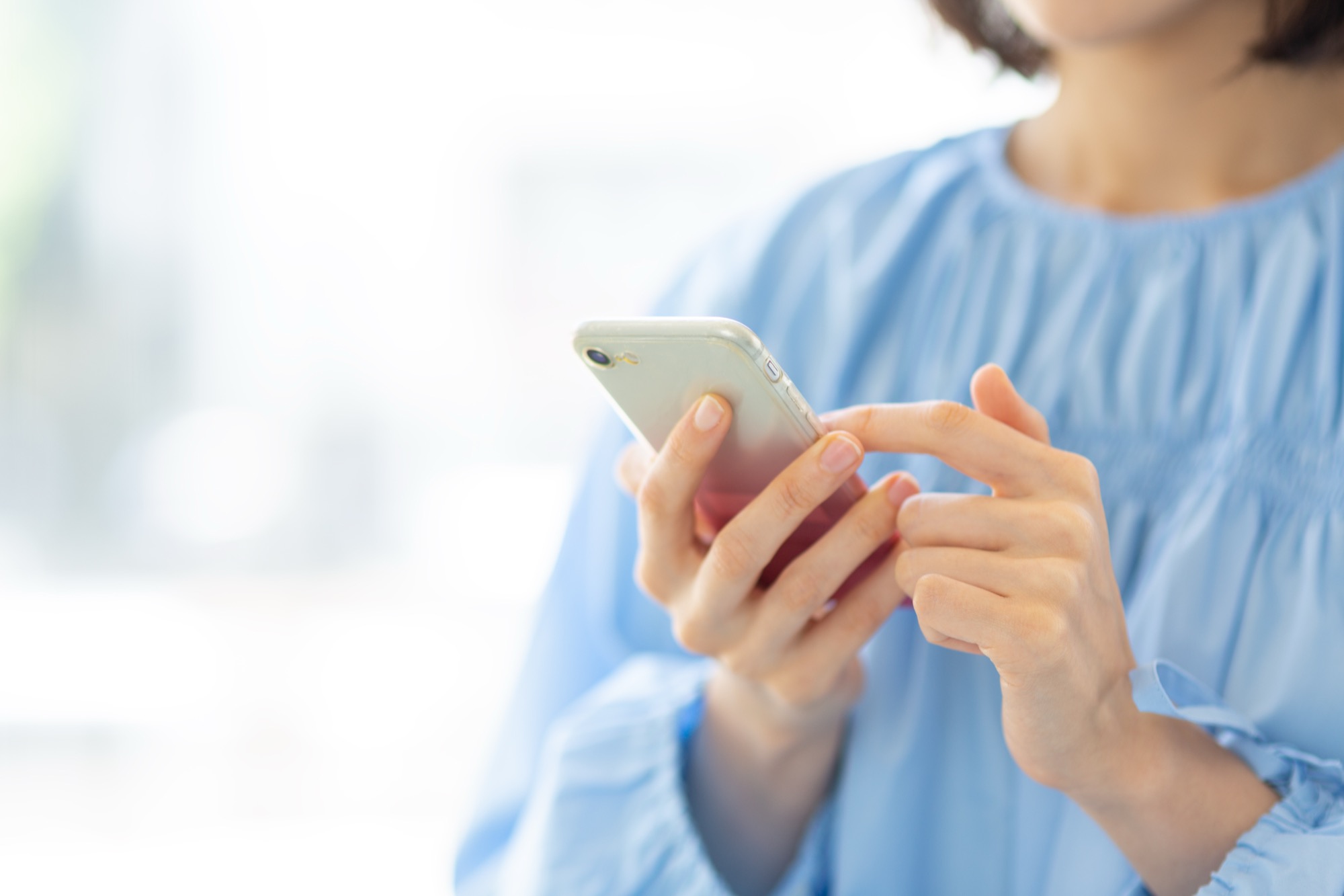 スマホを操作する女性の手元